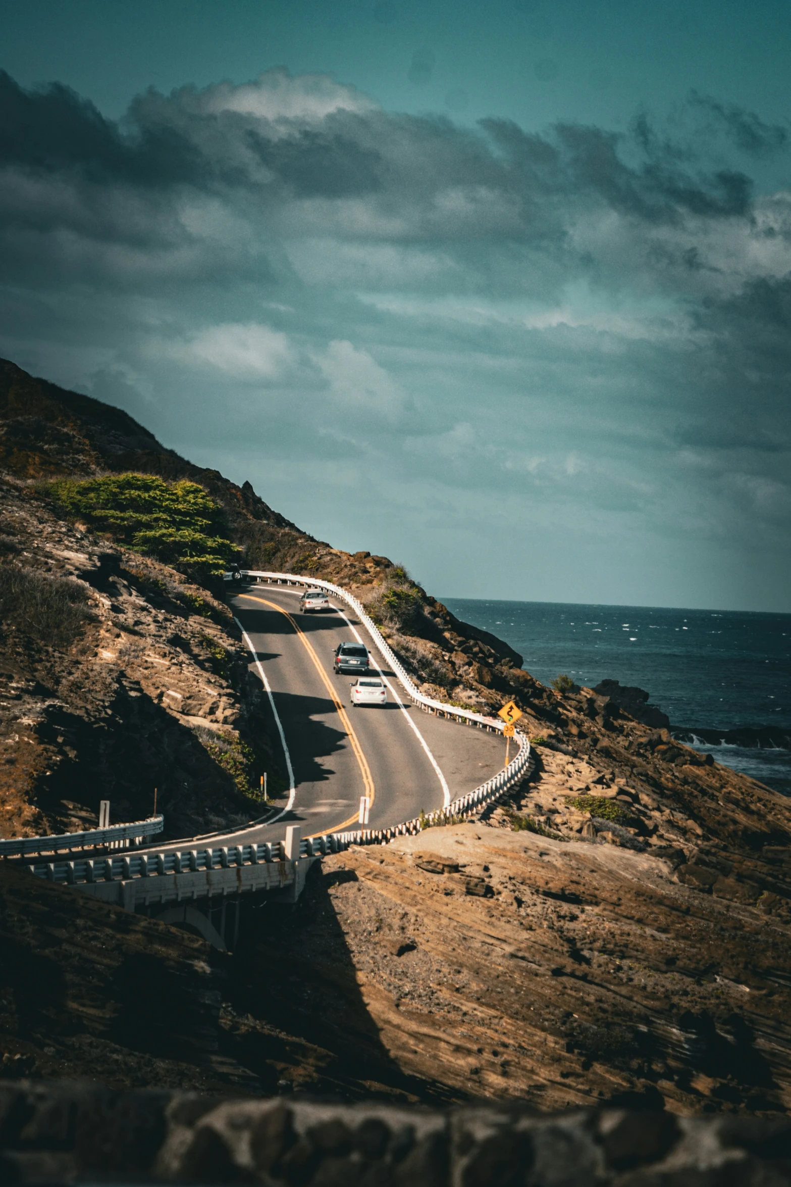 the cars are driving down the narrow road