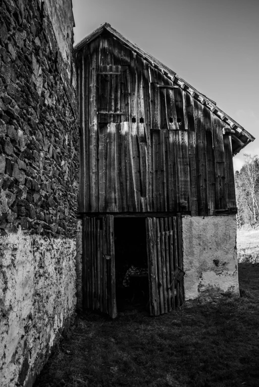 black and white pograph of a weathered barn with a roof