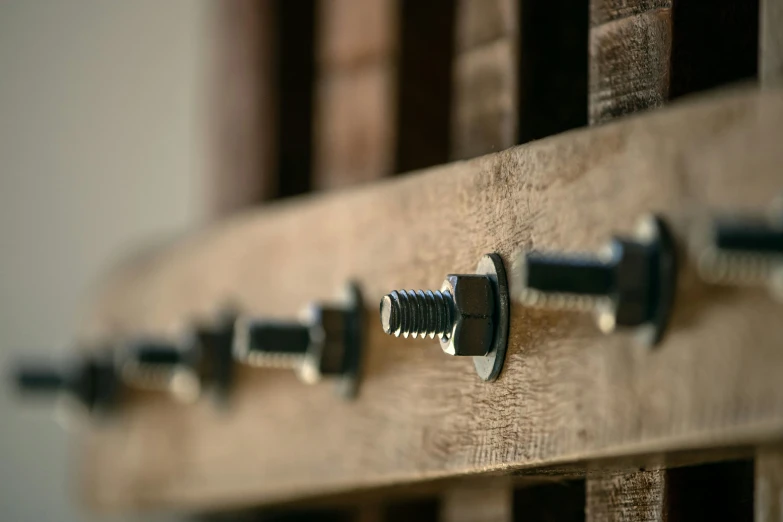 a set of metal screws on top of a wooden board