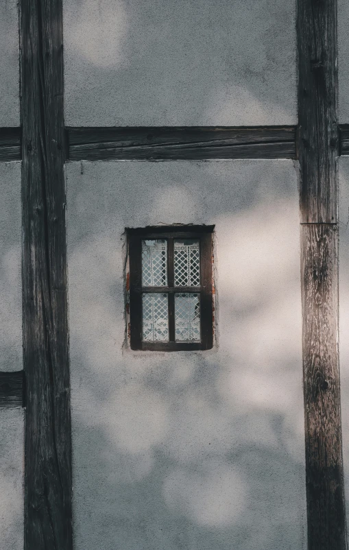 two windows in a corner that are between two wooden posts