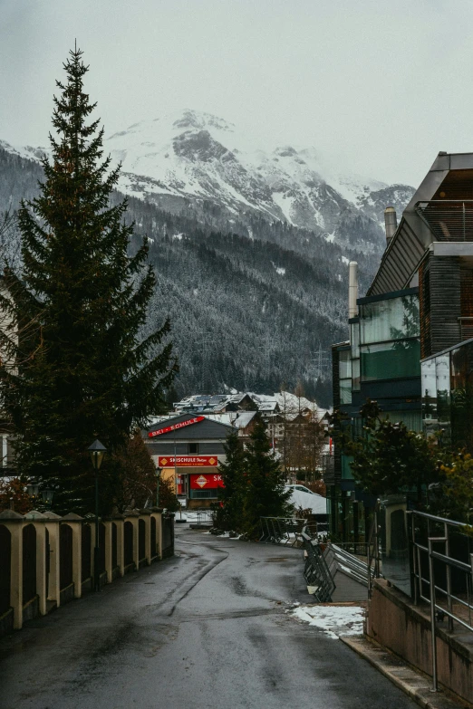 the street is empty of cars and is surrounded by tall mountains