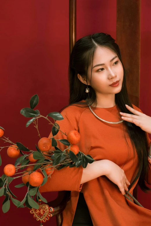 a woman in orange stands by some oranges
