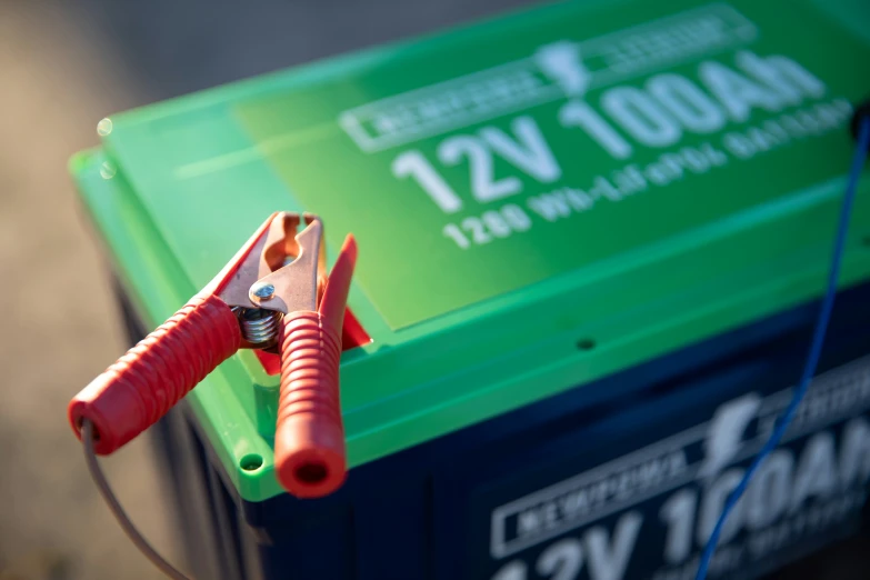 an open red and blue battery with a green and blue wire