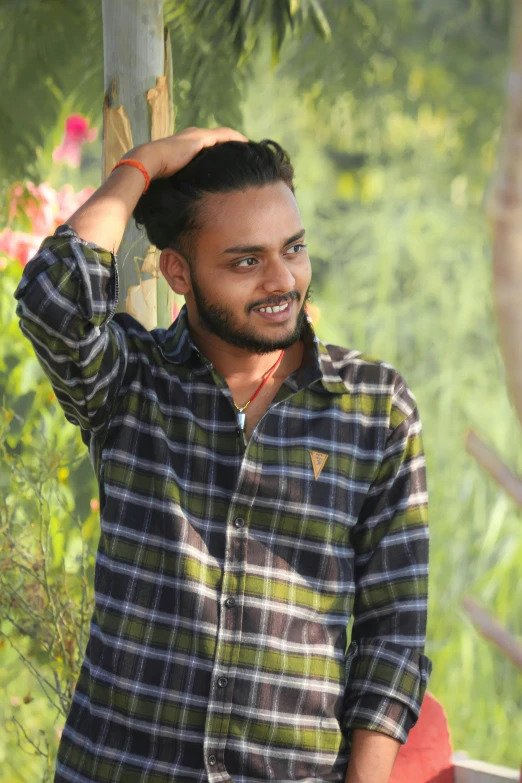 a man standing outside wearing a plaid shirt