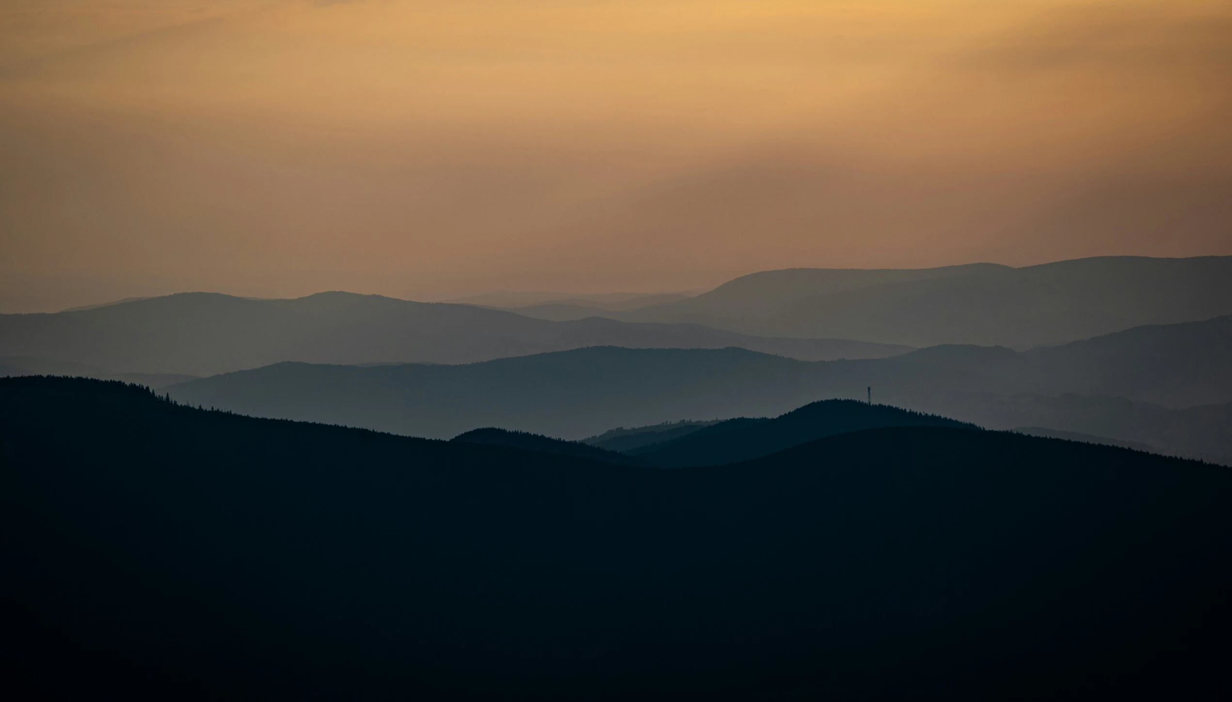 mountains are covered in dark and light grey haze