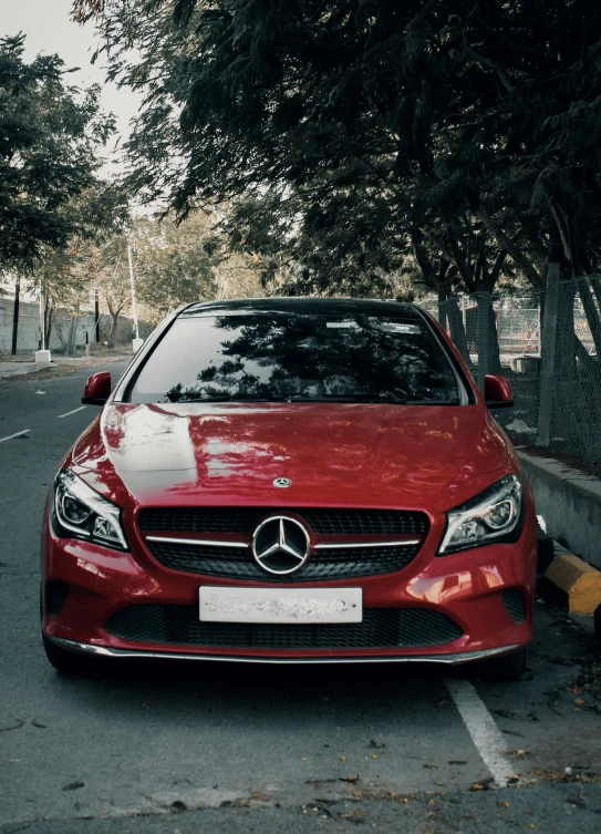 a mercedes car sitting at the side of a street