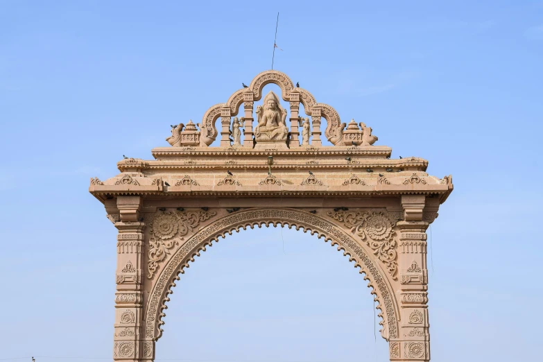 a large intricate arch stands against a blue sky