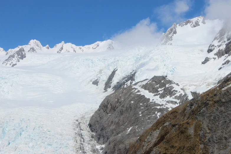 a very steep snowy mountain with snow on the side