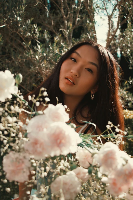 a woman posing for a po surrounded by white flowers