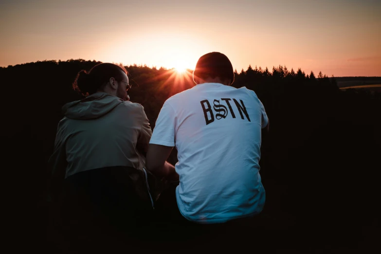 two people looking at the sunset with the sun going down