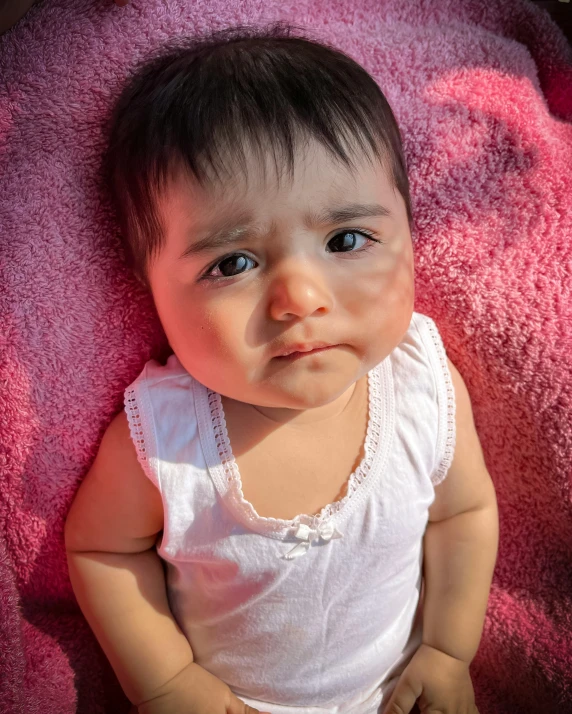 an asian baby looks directly at the camera