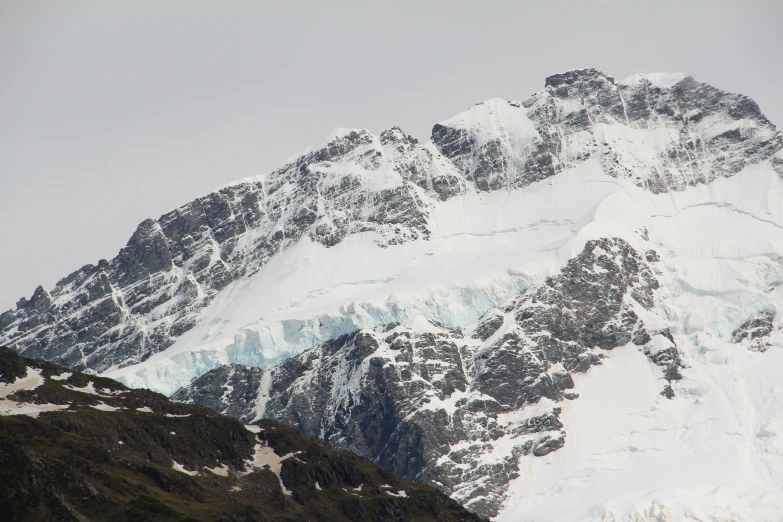 snow capped mountain peak and ground near grassy area