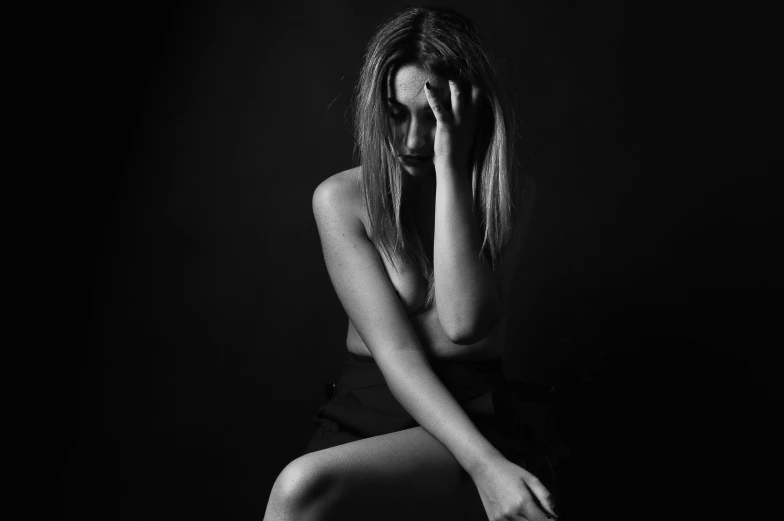 black and white po of woman leaning on wall