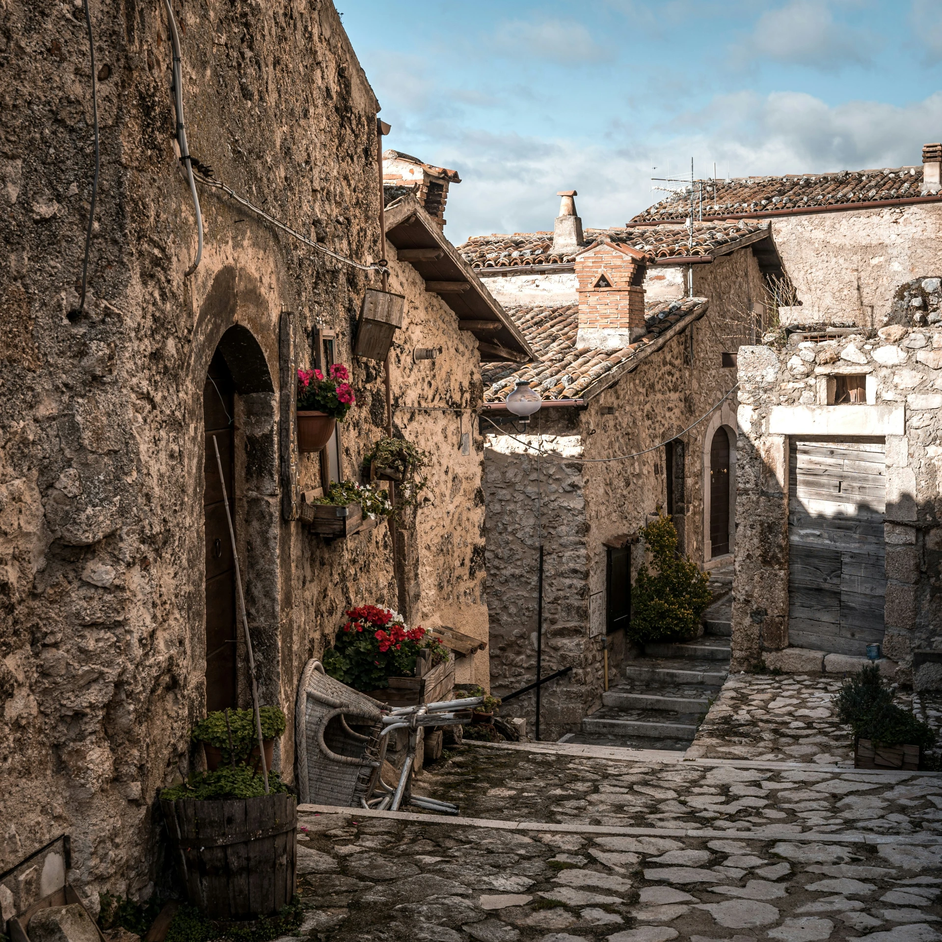 a cobblestone street lined with buildings and flowers