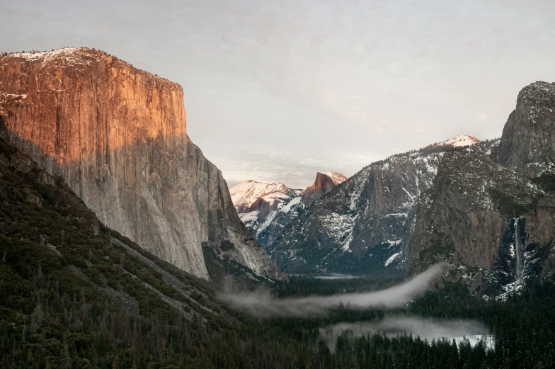 some mountains that are covered with snow and fog