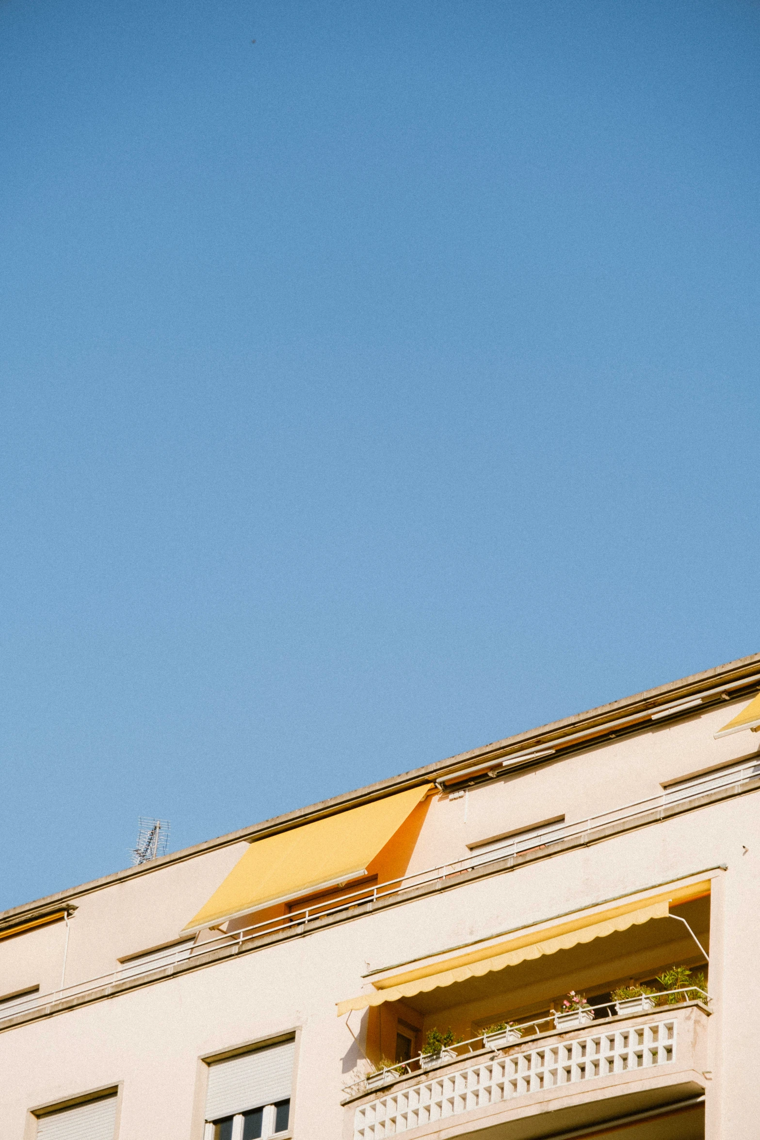 an orange kite is flying over a building