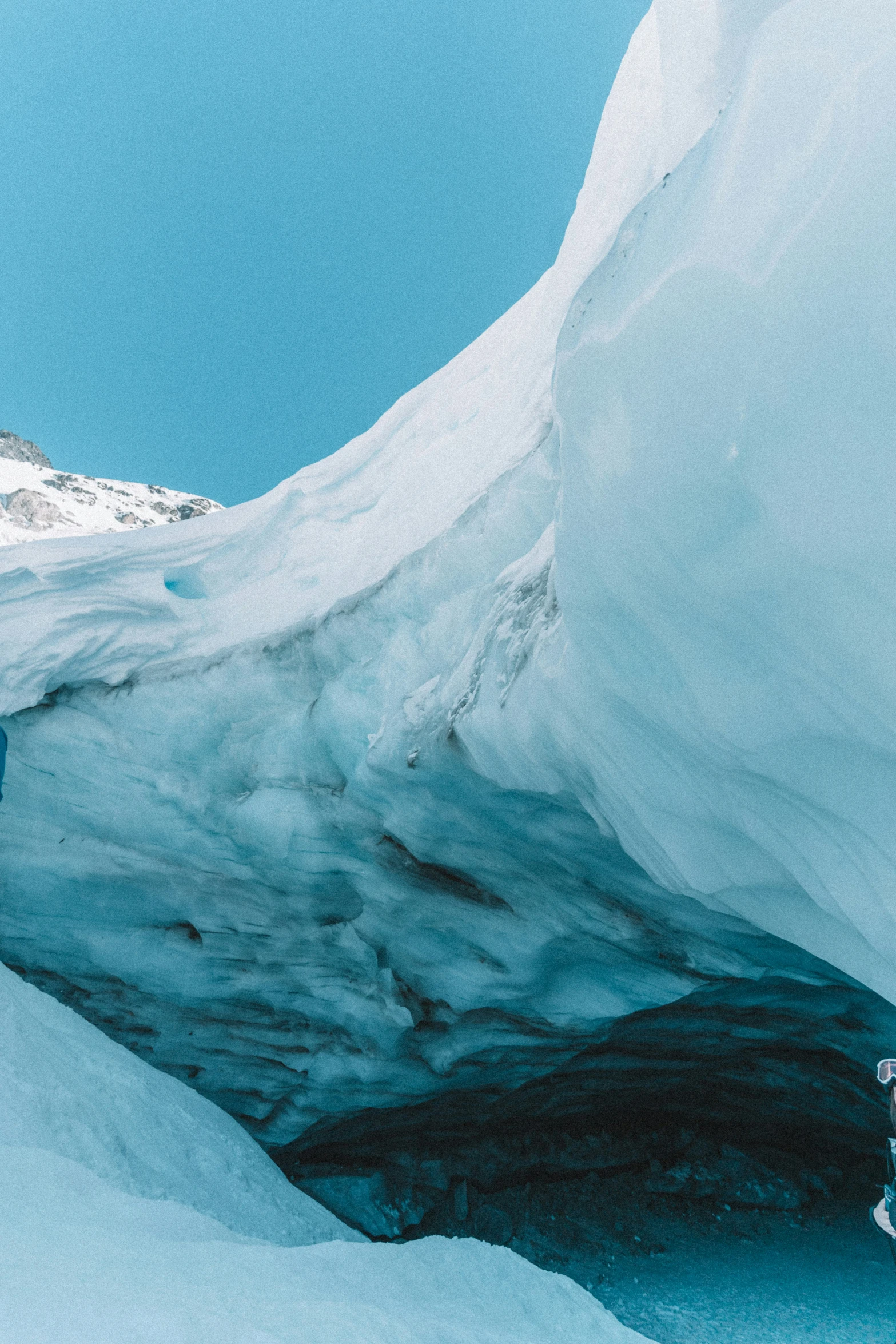 a man is climbing up the side of an ice cave