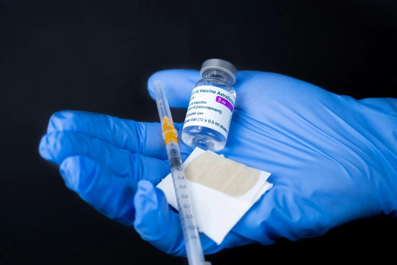 a person with gloves holding two medical supplies in their hand