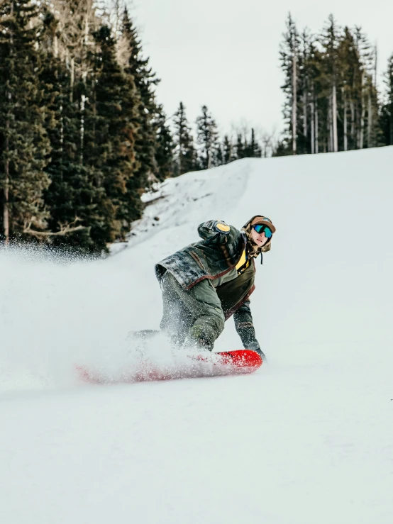 the man is snowboarding down the snowy hill