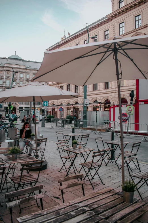 tables are set up on an open square with large umbrellas