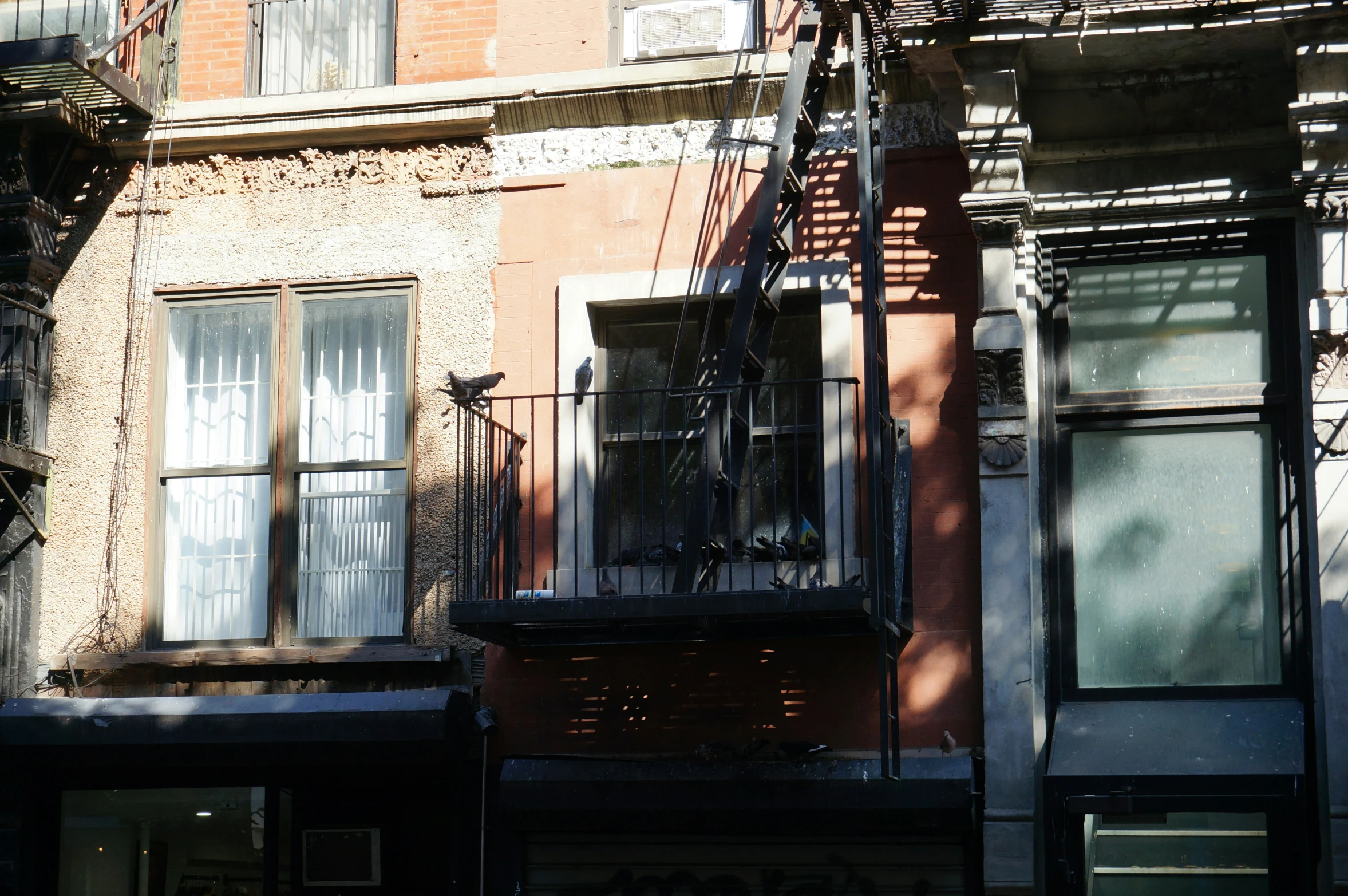 some old brick buildings with white windows and a wrought iron fence