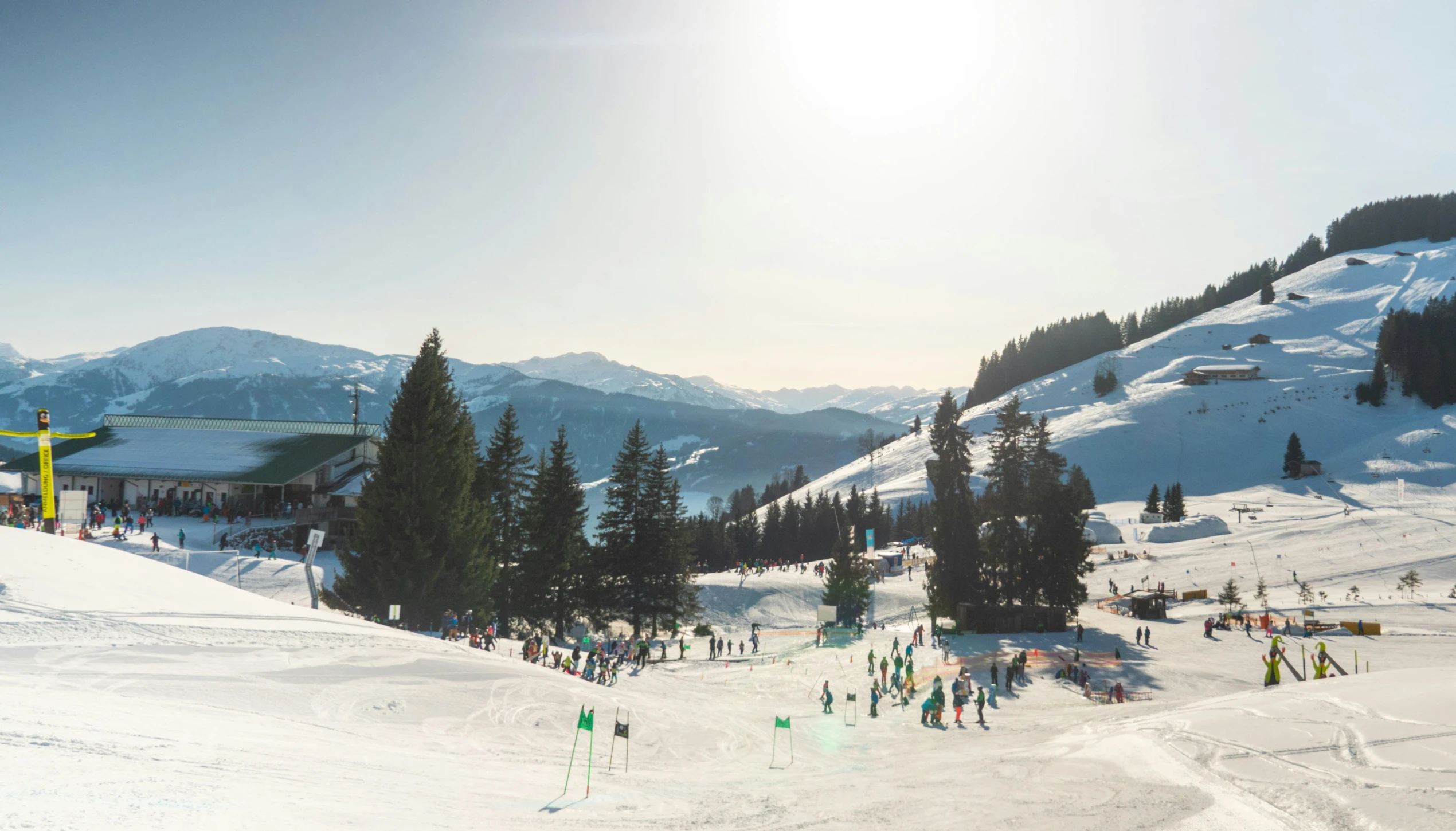 a group of people skiing down the snow on a sunny day