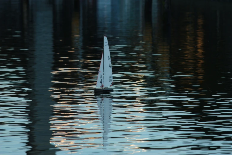 a small sail boat floating on the water