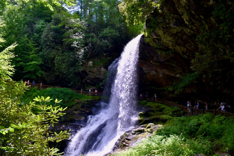 people are near the waterfall as the water pours