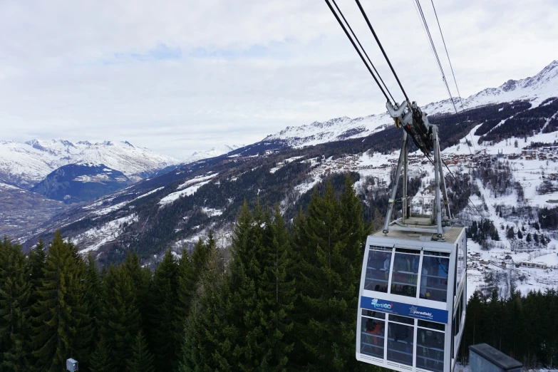 a gondola in a snowy mountain with mountains around