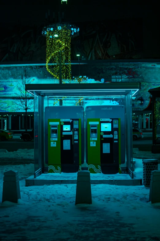 two telephone booths on a street at night