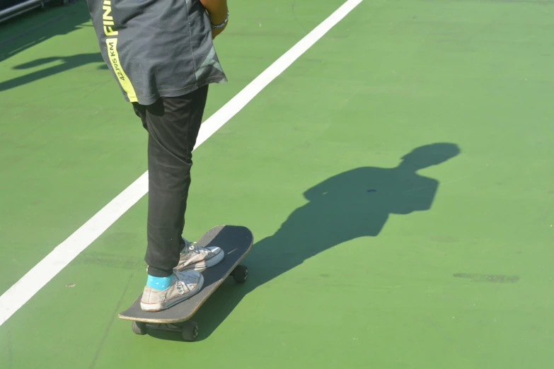 a person riding a skate board on a tennis court