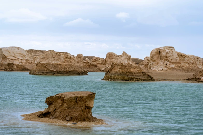 a large rock is in the water near some rocks