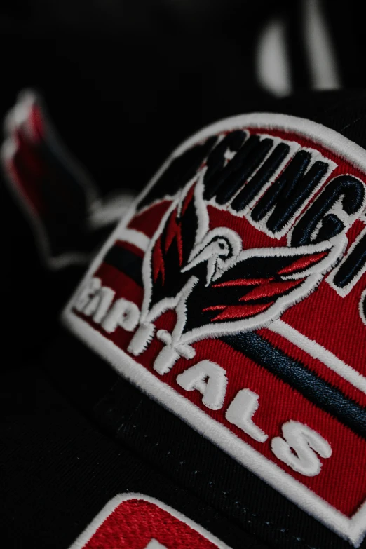 the emblem on a red and black baseball hat