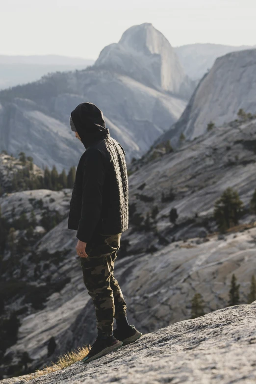 a young man standing on top of a mountain