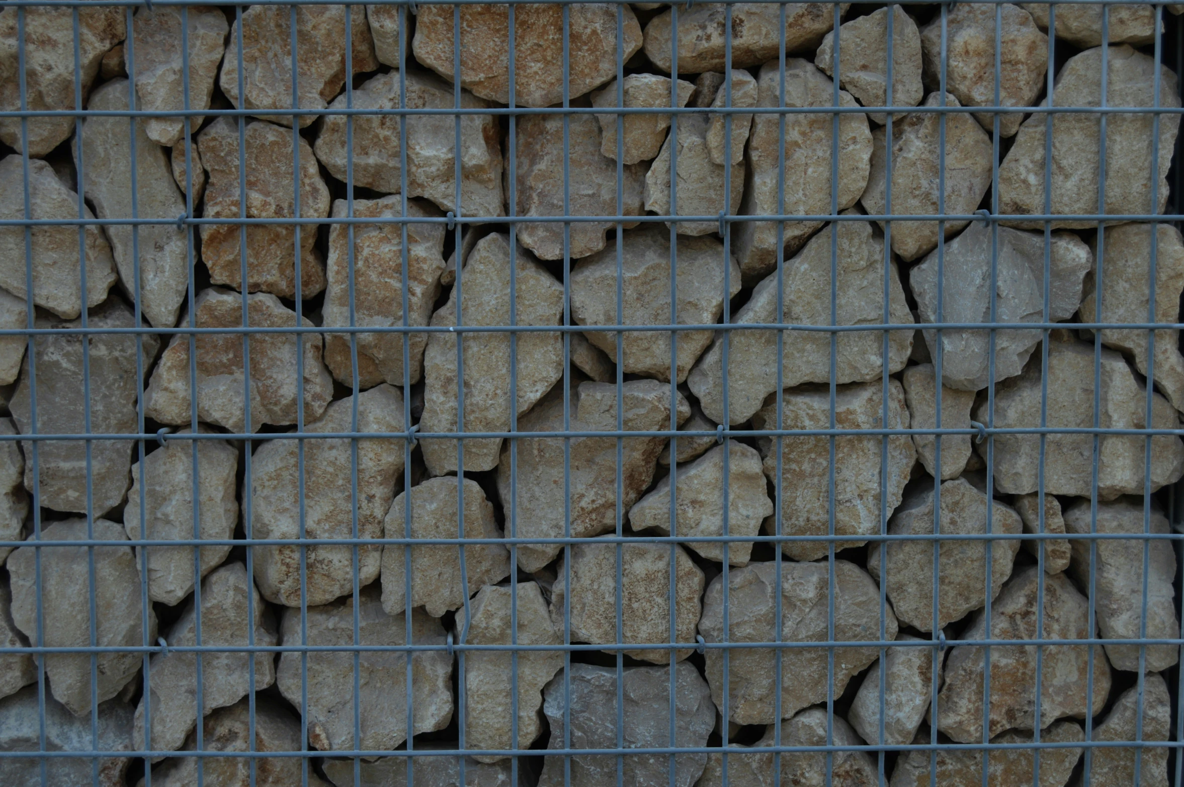 a fence covered in rock with a bird on it