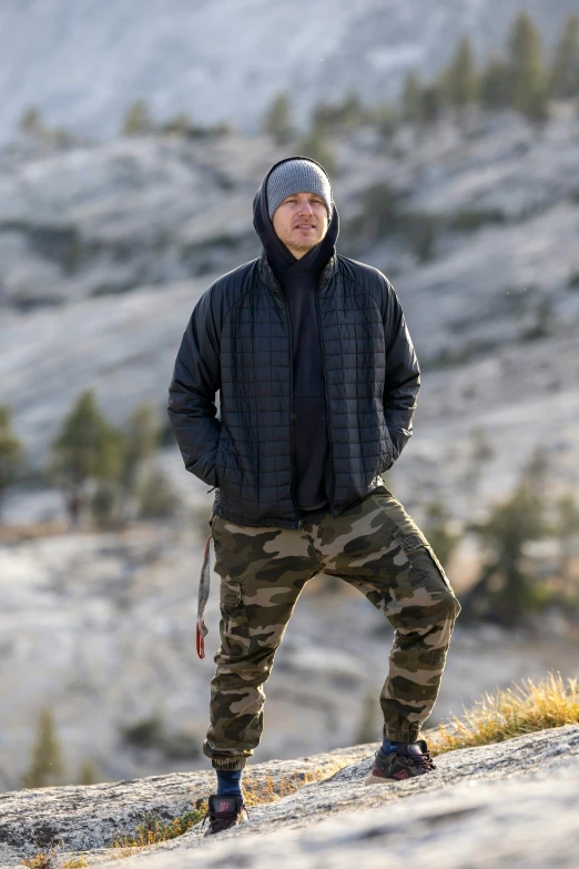 a man in grey hat standing on side of hill