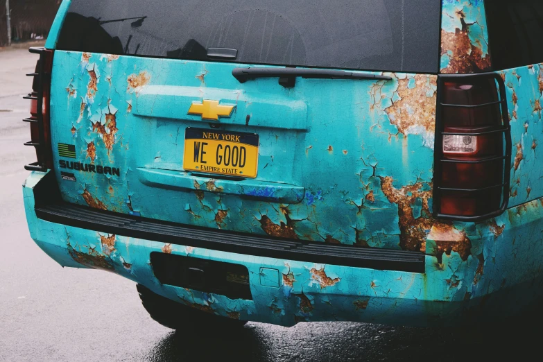 a rusty blue car with the name of the chevrolet emblem