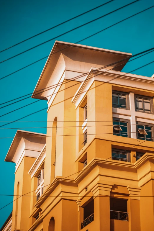 a tall building that is yellow and has multiple windows