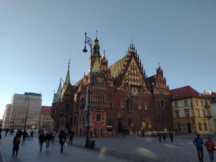 large old building with spires and a lot of people walking around