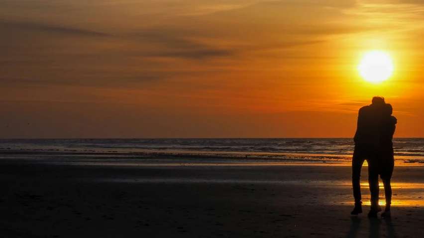 silhouette of person at the beach watching the sunset