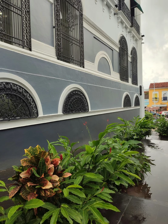 a large building with several plants next to it