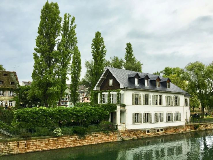 a large white house sitting beside a body of water