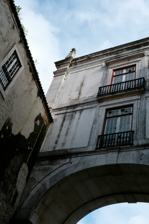 looking up at a building with a balcony overpass