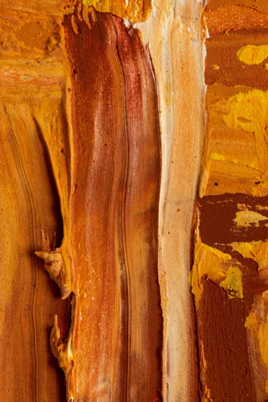 brown, white and yellow paint is on a wooden plank