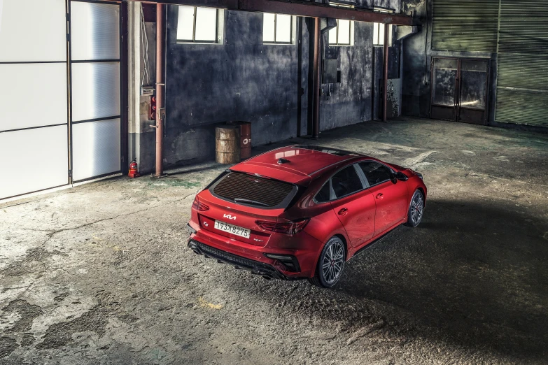 a red car parked inside of an empty garage