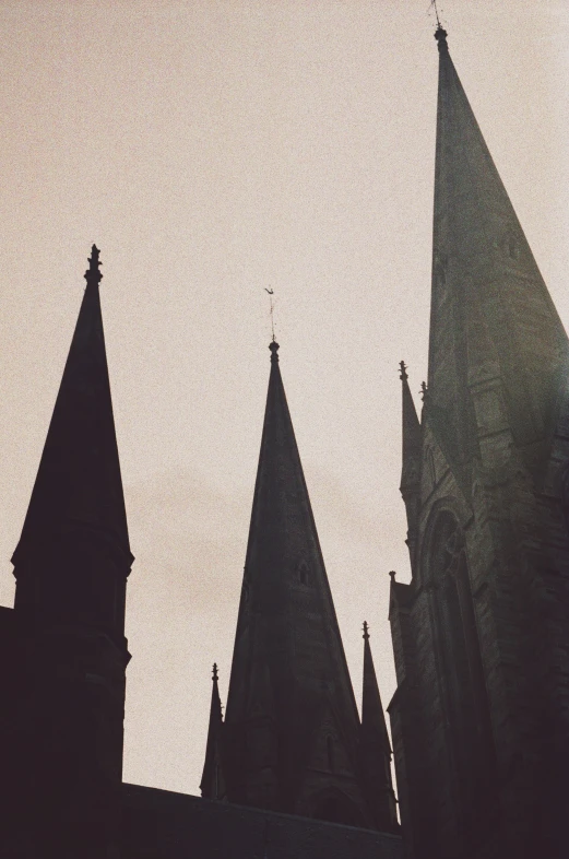 an old gothic church steeples in the distance