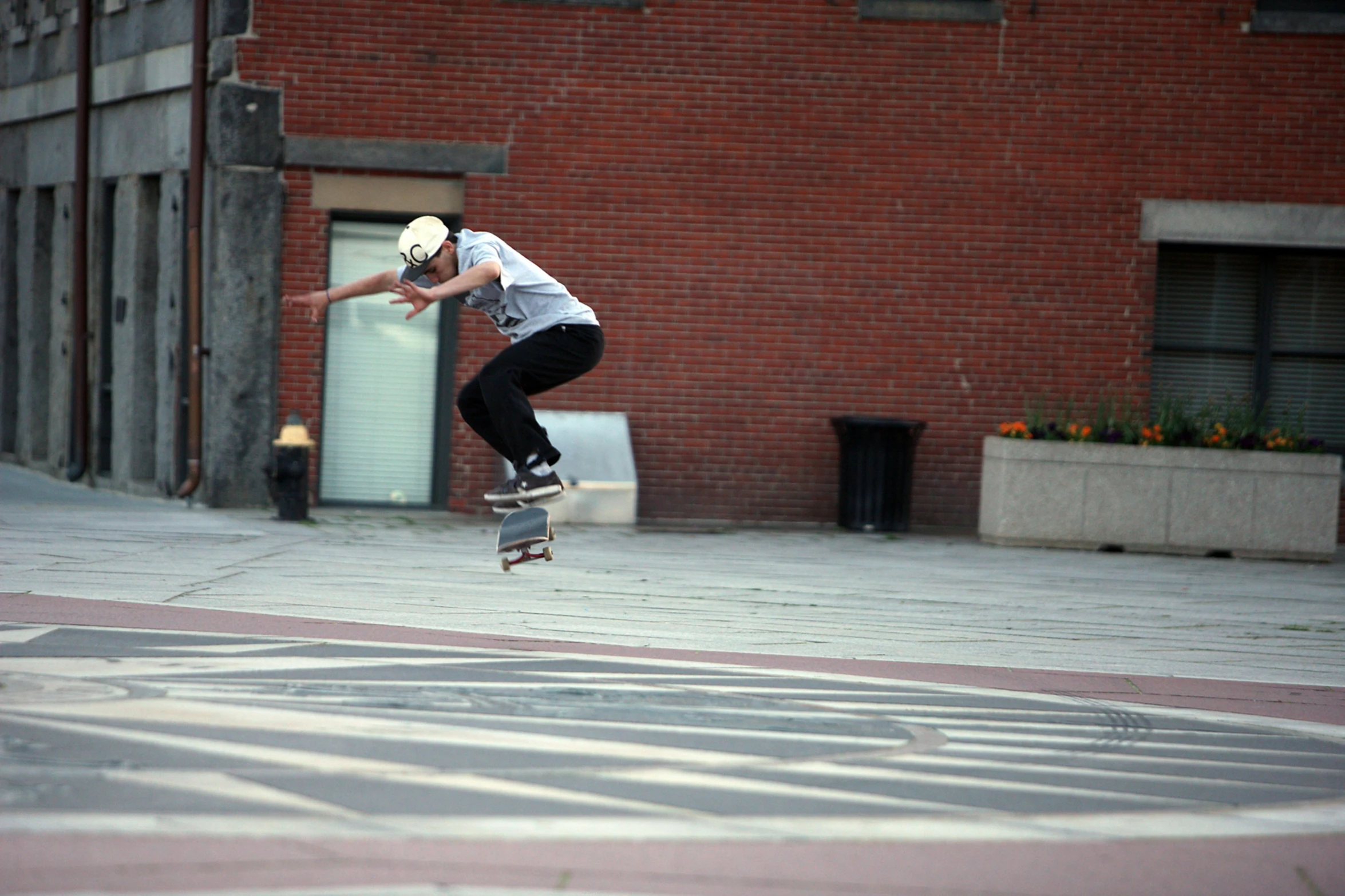 a skateboarder jumps off a brick curb