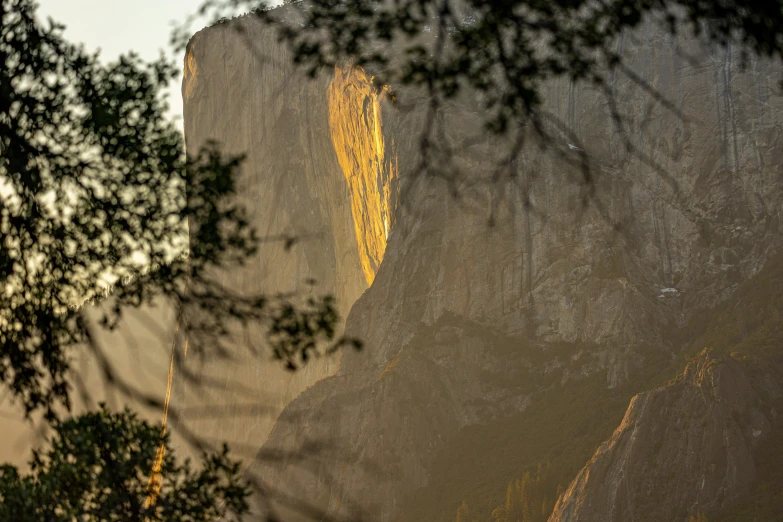 this is the view of a rocky cliff through some leaves