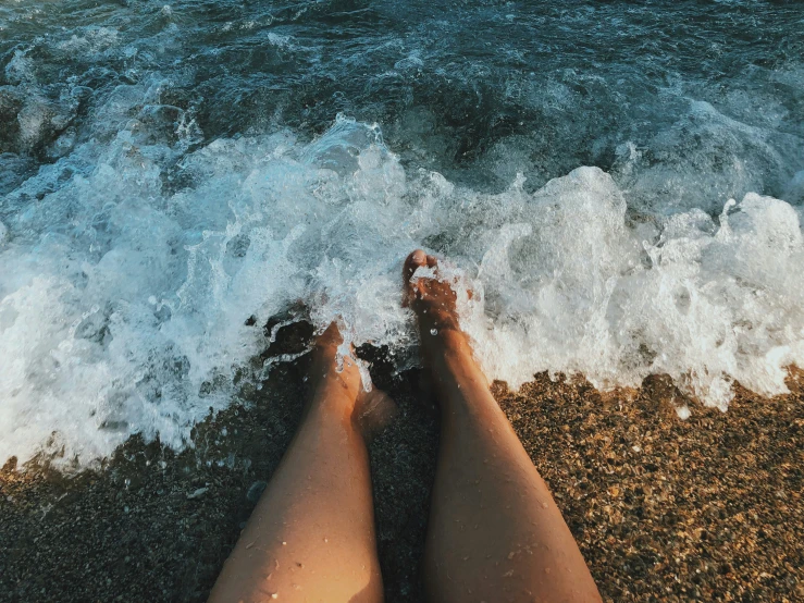 a person with feet in the ocean water