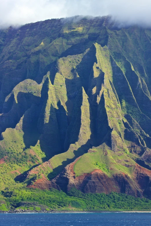 a boat sailing along the ocean near a mountain